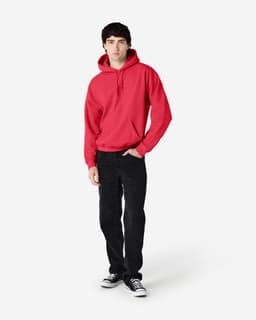 A red hooded sweatshirt worn by a model, paired with black trousers and shoes, featuring a logo on the garment.