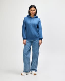 A blue hooded sweatshirt with a kangaroo pocket, paired with light blue jeans and white shoes.