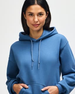 A blue hooded sweatshirt with a female model showcasing the product, featuring a logo on the fabric.