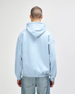 A light blue Gildan Heavy Blend adult hooded sweatshirt is displayed from the back, featuring a hood and relaxed fit.