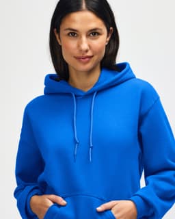 A blue hooded sweatshirt is worn by a model, featuring a drawstring and a branding logo.