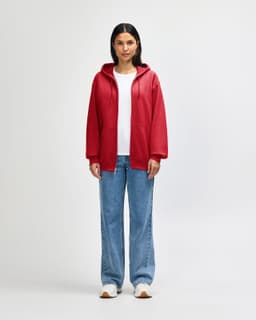 A red Gildan Heavy Blend adult full zip hooded sweatshirt on a model. The model wears black pants and sneakers.