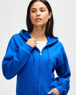A blue hooded sweatshirt features a full zip and is modelled by a man adjusting the hood. It has a logo.