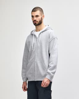 A grey Gildan Heavy Blend adult full zip hooded sweatshirt, featuring a logo and front pockets.