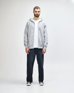 A grey full zip hooded sweatshirt featuring a front pocket and a hood. It has a logo on the side.