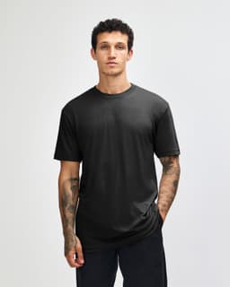 A unisex black CVC short sleeve t-shirt displayed on a model, featuring a simple design and fitted style.