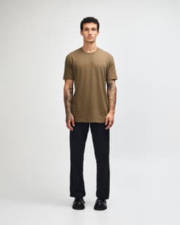 A model wearing a unisex short sleeve T-shirt in olive green, paired with black cargo pants and sneakers.