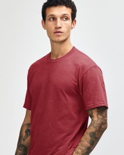 A unisex CVC short sleeve t-shirt in a deep red colour, displayed on a model with a neutral background.