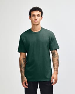 A model displays a unisex short sleeve t-shirt in dark green, featuring a logo on the front.