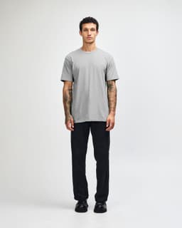 A grey unisex CVC short sleeve t-shirt worn with black cargo pants, featuring a simple design and casual fit.