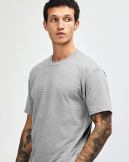 A grey unisex CVC short sleeve T-shirt displayed on a model with a plain background. It features a subtle logo.