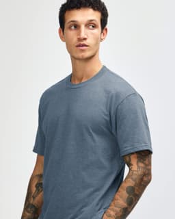 A unisex short sleeve t-shirt in a muted blue colour, featuring a simple design and a logo.