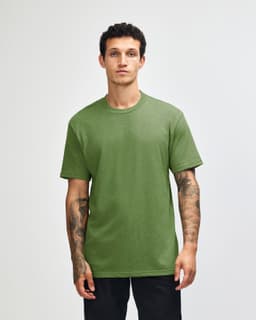 A unisex short sleeve T-shirt in a vibrant green colour, displayed on a model standing against a plain background.