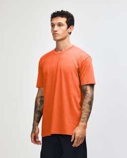 An orange unisex CVC short sleeve t-shirt displayed on a model, featuring a casual fit and a logo.