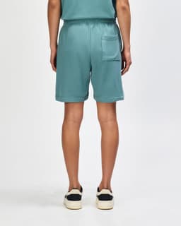 Teal unisex gym shorts with an elastic waistband and a single back pocket. Features branding on the garment.