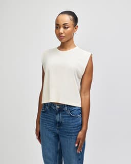 A sleeveless cream muscle T-shirt with a relaxed fit, featuring an unbranded design.