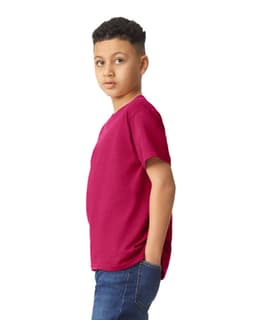 A youth t-shirt in a vibrant magenta colour, featuring a logo, worn by a young person.