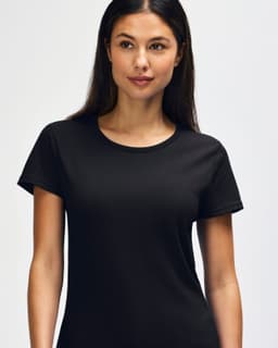 A black Gildan Heavy Cotton Ladies' T-Shirt displayed on a smiling woman, featuring a simple design and casual fit.