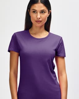 A purple Gildan Heavy Cotton Ladies' T-Shirt displayed on a smiling woman, featuring a round neck and short sleeves.