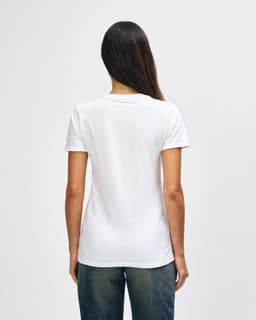 A white ladies' t-shirt with a fitted design, featuring a logo on the back, worn with blue jeans.