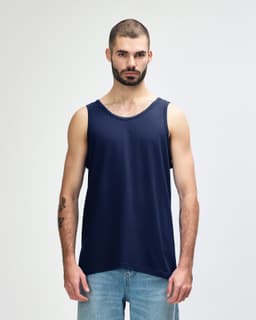A navy Gildan Heavy Cotton adult tank top on a model standing against a plain background. The tank top has a logo.