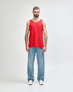 A red Gildan Heavy Cotton adult tank top displayed on a model, paired with black pants and shoes.