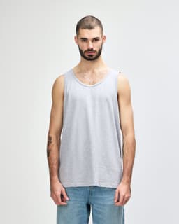 A grey adult tank top with a round neckline and a logo on the front, styled on a male model.