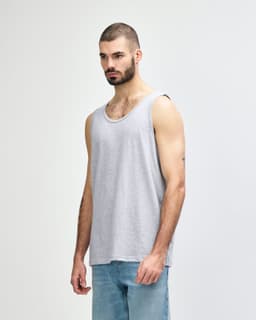 A grey Gildan Heavy Cotton adult tank top displayed on a model, featuring a plain design and a logo.