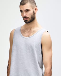 A light grey tank top featuring a round neck and wide straps, with a small logo on the side.