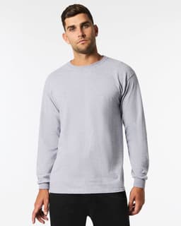 A man wearing a light grey long sleeve t-shirt with a round neck, featuring a logo on the front.