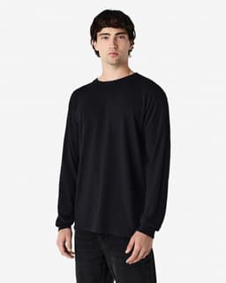 A model wearing a black Gildan Heavy Cotton adult long sleeve T-shirt. The shirt features a simple design and a logo.