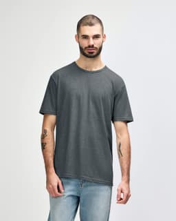 A man wearing a dark grey Gildan Softstyle adult T-shirt, paired with light blue jeans. The t-shirt has a logo.