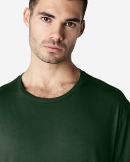 A green Gildan Softstyle adult T-shirt featuring a round neckline, modelled by a man.