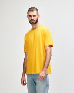 An orange Gildan Softstyle adult T-shirt is displayed on a model in profile view.