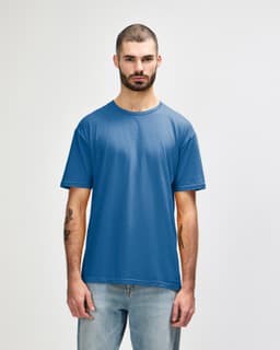 A blue Gildan Softstyle adult T-shirt displayed on a male model, featuring a basic crew neck and short sleeves.