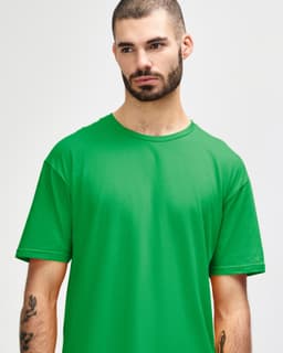 A plain green Gildan Softstyle adult T-shirt displayed on a model with a neutral expression.