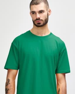 A green adult T-shirt displayed on a model, featuring short sleeves and a relaxed fit. It has a logo on it.