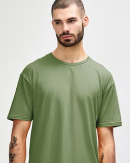 A model wearing a short-sleeved, olive green Gildan Softstyle adult t-shirt. The shirt features a simple design and a logo.