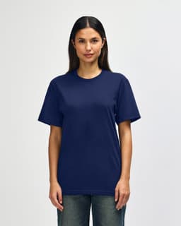 A man wearing a navy Gildan Softstyle adult t-shirt with a relaxed fit, standing against a plain background.