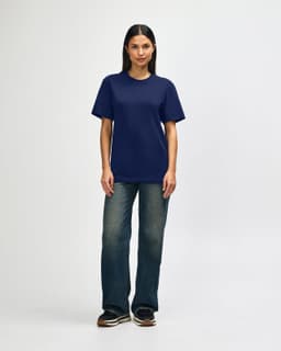 A navy Gildan Softstyle adult T-shirt displayed on a male model, paired with light blue jeans and white shoes.