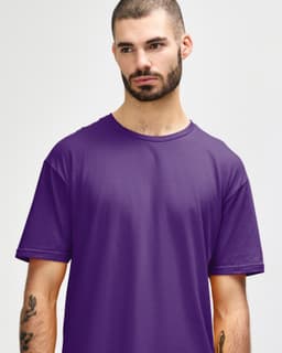 A man is wearing a purple Gildan Softstyle adult t-shirt, displaying a relaxed neckline and a casual style.