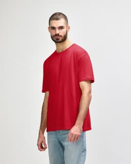 A red Gildan Softstyle adult T-shirt is displayed on a model wearing blue jeans. The shirt features a logo.