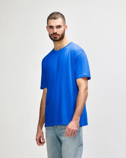 A blue Gildan Softstyle adult T-shirt displayed on a model, featuring a basic crew neck design and short sleeves.
