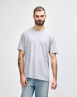 A model wears a grey Gildan Softstyle adult T-shirt featuring a relaxed fit and a crew neckline.