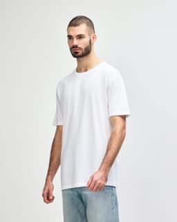 A white Gildan Softstyle adult t-shirt displayed on a model, with a simple design and soft fabric texture.