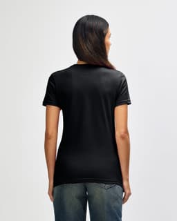 A black Gildan Softstyle ladies' T-shirt displayed on a model from the back, featuring short sleeves and a relaxed fit.