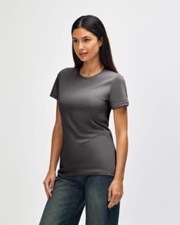 A grey Gildan Softstyle ladies' t-shirt displayed on a model, featuring a fitted design and short sleeves.