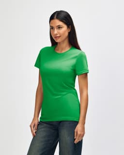A green Gildan Softstyle ladies' T-shirt displayed on a model from the side, paired with jeans.