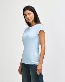 A light blue Gildan Softstyle ladies' T-shirt displayed on a model, featuring a round neckline and short sleeves.