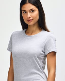A grey Gildan Softstyle Ladies' T-Shirt displayed on a model, featuring a casual fit and short sleeves.